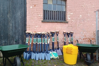Tree planting equipment: Spades and buckets and a wheelbarrow