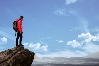 Hiker on the top of a cliff point looking out into the distance