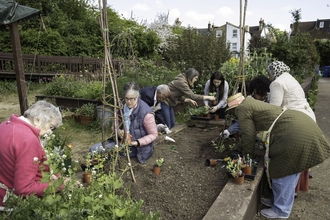 Group of people tending to community garden