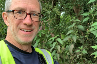 Head and shoulders photo of Peter White wearing a yellow reflective jackets take during volunteering at Stevenage Brook