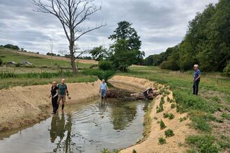 Volunteers planting native plants on the newly graded banks of the river Ash