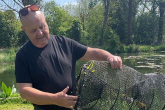 Tony Booker with American Signal Crayfish trap at Sabey's Pool - a fishing lake