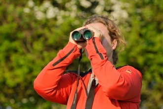Young woman birdwatching at Rutland Water