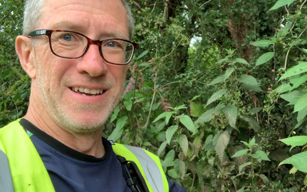 Head and shoulders photo of Peter White wearing a yellow reflective jackets take during volunteering at Stevenage Brook