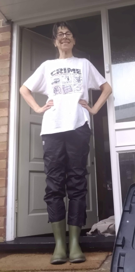 Jayne Schwartz standing in front of her door wearing wellies and a big smile