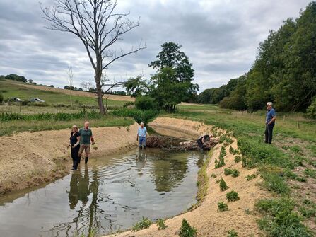 Volunteers planting native plants on the newly graded banks of the river Ash